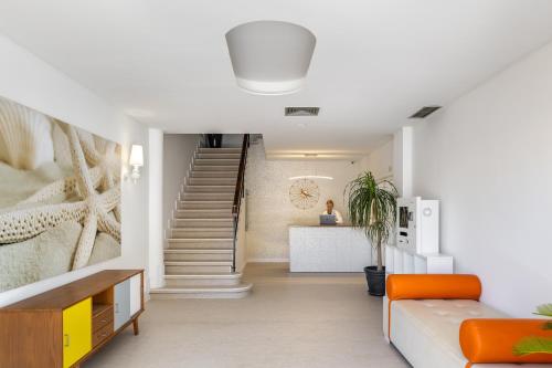 a living room with a staircase and orange couch at Hostal Neptuno in Paguera