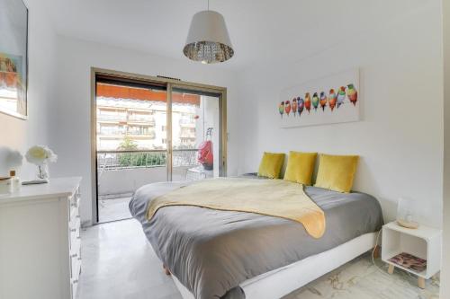 - une chambre blanche avec un grand lit et des oreillers jaunes dans l'établissement Superb 1 bedroom appartement - close to Croisette, à Cannes