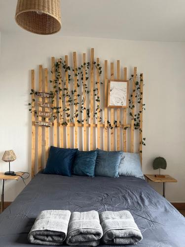 une chambre avec un lit avec une tête de lit en bois dans l'établissement Le Vincent I Proche de la gare, à Orléans