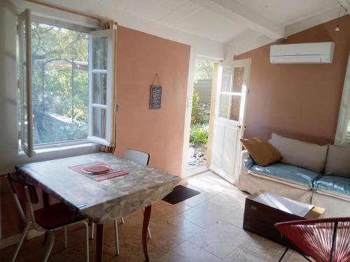 un salon avec une table et un canapé dans l'établissement Mazet terrasse et jardin Nîmes, à Nîmes