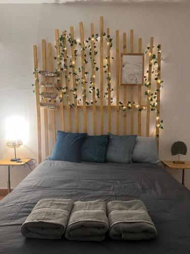 - un lit avec une tête de lit en bois éclairée dans l'établissement Le Vincent I Proche de la gare, à Orléans