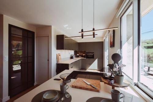 a kitchen with a table and a large window at Domaine d'Essendiéras in Saint-Médard-dʼExcideuil