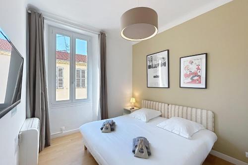 une chambre avec un lit blanc et une grande fenêtre dans l'établissement Cannes central apartment lively area near beaches, à Cannes