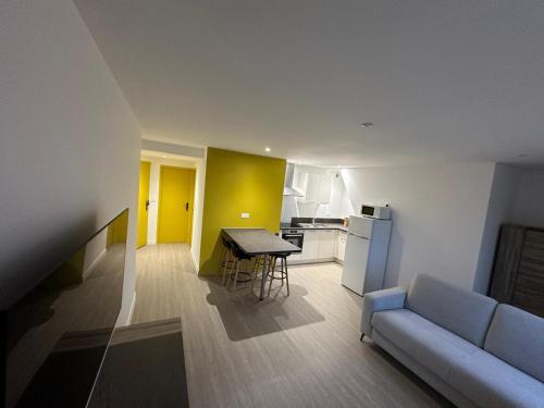 un salon avec un canapé et une table et une cuisine dans l'établissement Appartement Djo&Juh 4, à Granville