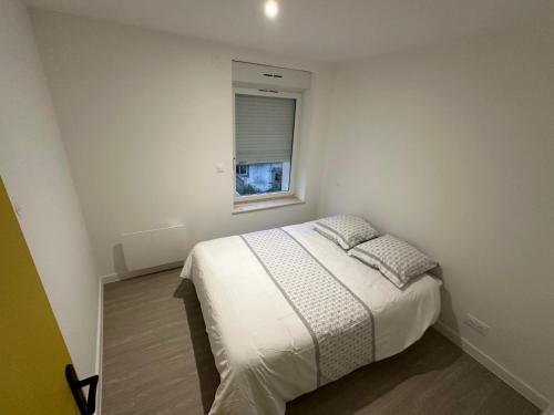 une chambre blanche avec un lit et une fenêtre dans l'établissement Appartement Djo&Juh 4, à Granville