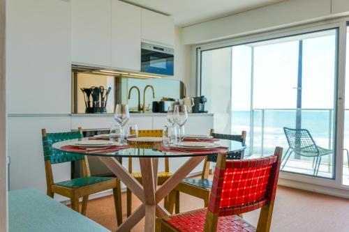 une salle à manger avec une table et des chaises en verre dans l'établissement Superbe studio vue mer entièrement rénové - 4 personnes, à Les Sables-dʼOlonne