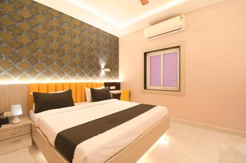 a bedroom with a large bed and a window at Hotel Sai Swastik in Puri
