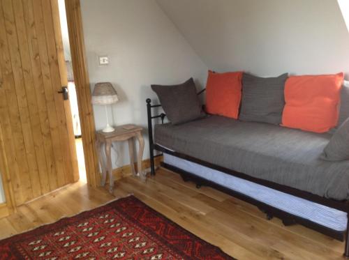 a room with a couch with orange and gray pillows at Woodland Guesthouse in Stow on the Wold