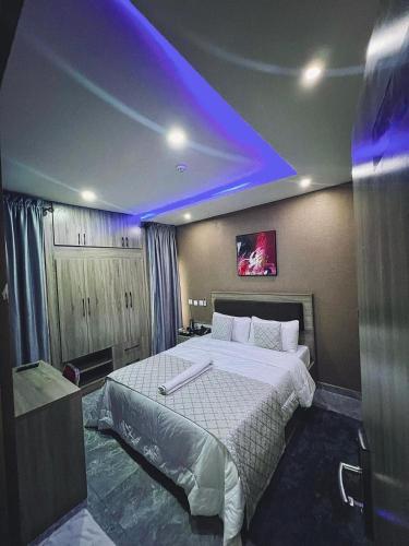 a bedroom with a large bed with a purple lighting at Macdestly Apartment in Abuja