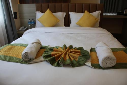un letto con asciugamani e cuscini sopra di Sinamangal Airport Hotel a Kathmandu