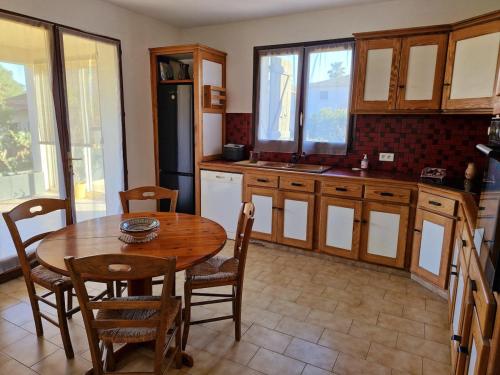 une cuisine avec une table en bois et une table et des chaises dans l'établissement Villa à quelques pas de la plage, à Santa-Lucia-di-Moriani
