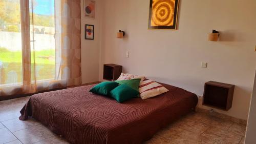 une chambre avec un lit avec deux oreillers dessus dans l'établissement Villa à quelques pas de la plage, à Santa-Lucia-di-Moriani