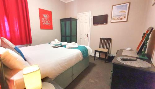 a bedroom with a bed and a desk and a television at Yardley Manor Hotel in Torquay