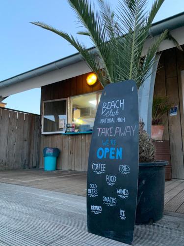 a chalkboard sign sitting in front of a restaurant at HÜBSCHES FERIENHAUS IN OUDDORP - fußläufig zum Strand und Zentrum in Ouddorp