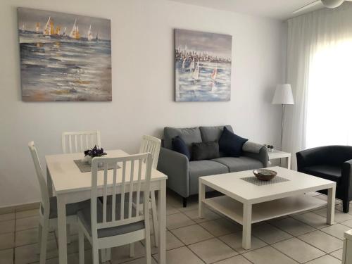 a living room with a couch and a table at Stylish 1BR Apt With Pool - Near Mall, Restaurants & Shops in Paphos