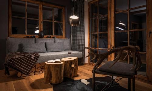 a living room with a couch and a chair and logs at Das Chalet in Schladming