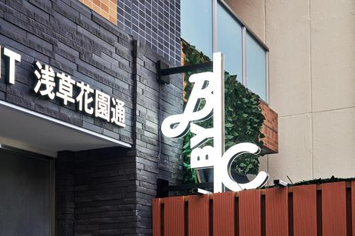 a sign on the side of a building at BbyC APARTMENT 浅草花園通 レンタカー&サウナ付ホテル in Tokyo