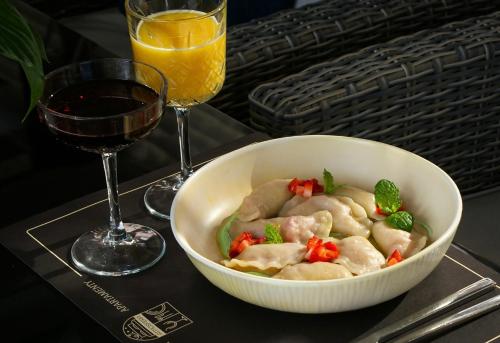 a bowl of food on a table with a glass of wine at Apartamenty Atmosfera Bytów in Bytów