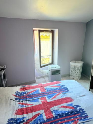 a bedroom with an american flag blanket on a bed at Charmante maison de village provençale in Régusse