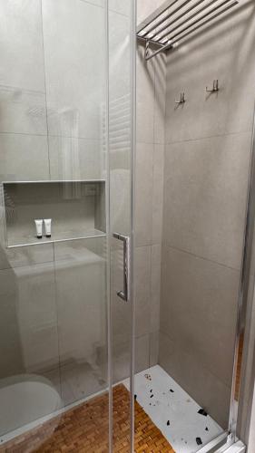 a shower with a glass door in a bathroom at Oda Zen Albania in Tirana