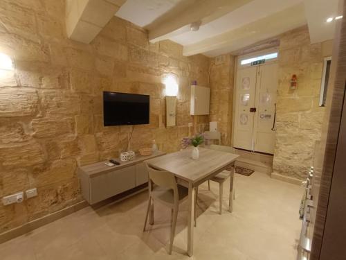 Una televisión o centro de entretenimiento en Kalkara Maisonette in the Alley