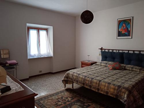 a bedroom with a bed and a window at HOME L'UPUPA AMIATA in Salaiola