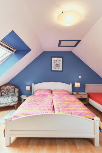 un lit dans une chambre avec un mur bleu dans l'établissement Cottage Batz - Moulin de Kerellec, à Plougoulm