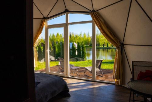 a bedroom in a yurt with a large window at Greenery Kupolai in Kalveliai