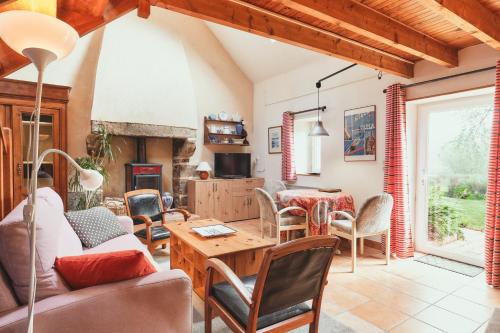 a living room with a table and chairs at Cottage Batz - Moulin de Kerellec in Plougoulm