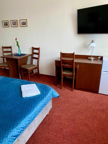 a hotel room with a bed and a desk and a tv at Yacht Club Residence Sopot in Sopot