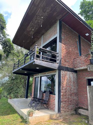 a house with a balcony and two chairs on a porch at Eco Leisure Kadugannawa Reach in Mawanella