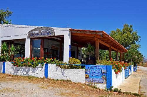 a small building with flowers in front of it at Orthi Ammos in Frangokastello