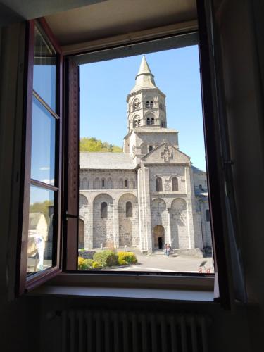a view of a church through a window at Hôtel restaurant Notre Dame in Orcival