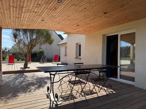une table de pique-nique sur une terrasse avec des chaises dans l'établissement La maison de la Corniche, à Plouhinec