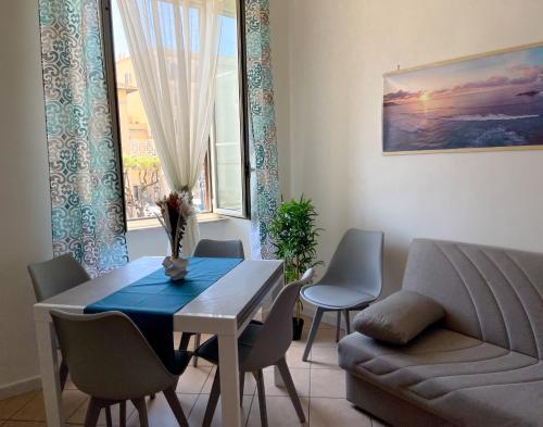 a living room with a table and a couch at NIMPHAEA BLUE APARTMENT - Elegant Central Flat, Walk to Beach & Train Station in Nettuno