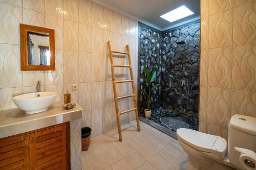 ein Badezimmer mit Toilette, Waschbecken und Dusche in der Unterkunft Stylish 3 BR Villa Near Canggu in Canggu