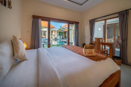 ein Schlafzimmer mit einem großen weißen Bett und einem Balkon in der Unterkunft Stylish 3 BR Villa Near Canggu in Canggu