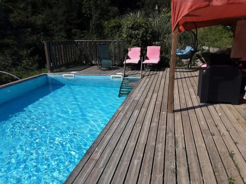 a swimming pool on a wooden deck with a table and chairs at Le box,magnifique pavillon privé in Rigaud