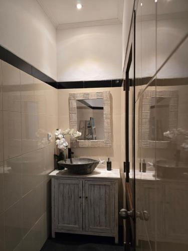 Un baño con lavabo y ducha de cristal. en Villa Mustika, en Ubud