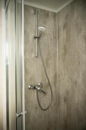 a shower with a shower head on a wall at Leeuwendamme in Serooskerke