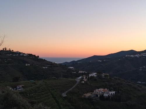 a sunset on a hill with a road on it at Malaga Hills Double Comfort Boutique & Wellness Eco-Hotel -Adults Only- in Cómpeta