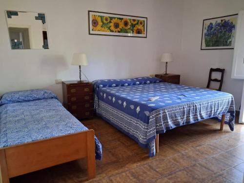 a bedroom with two beds and a mirror at Villa Eucalipti immersa nel verde e sul mare in Magazzini