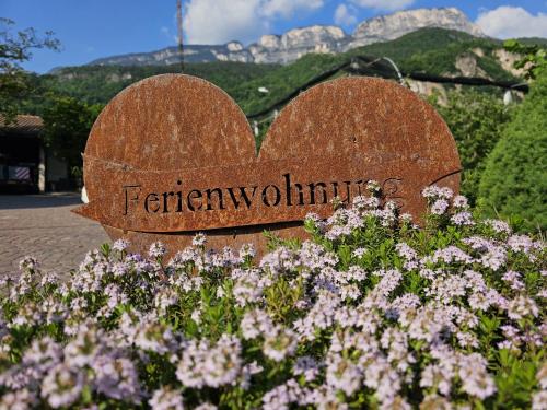 a sign for a garden with purple flowers at Versigglhof in Appiano sulla Strada del Vino