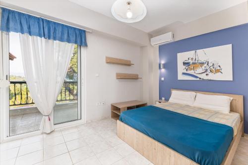 a bedroom with a blue bed and a large window at Melora Mare 2 Bedroom Villa Private Pool in Paliouri