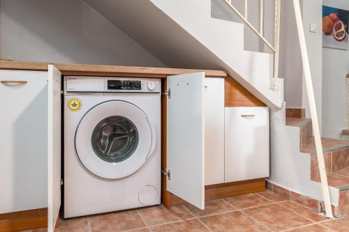 a washer and dryer in a room with stairs at Melora Mare 2 Bedroom Villa Private Pool in Paliouri