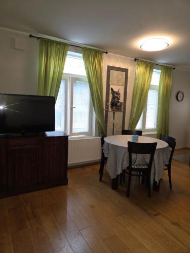 a living room with a table and a television at Suur-Ameerika Apartment in Tallinn