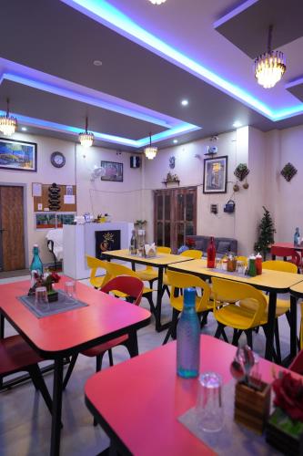 Un comedor con mesas y sillas amarillas. en Hotel Singhova, en Patna