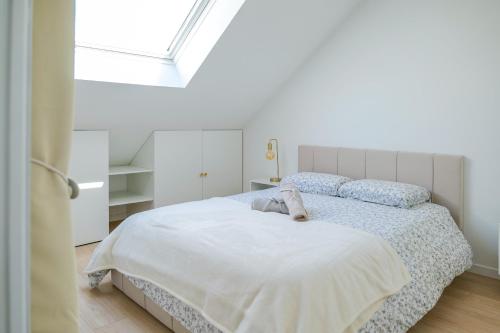 une chambre blanche avec un lit et une fenêtre dans l'établissement Très bel appartement lumineux et au calme - 2 personnes, à Angers