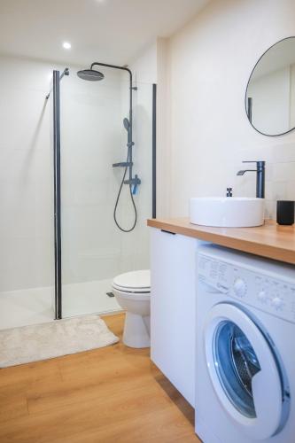 La salle de bains est pourvue d'un lave-linge et d'une douche. dans l'établissement Très bel appartement lumineux et au calme - 2 personnes, à Angers