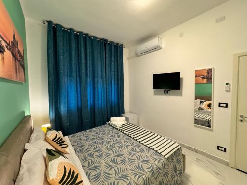 a bedroom with a bed and a blue curtain at United Residence in Venice